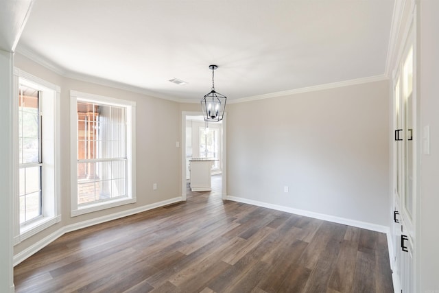 unfurnished dining area with dark wood-type flooring, crown molding, and a notable chandelier