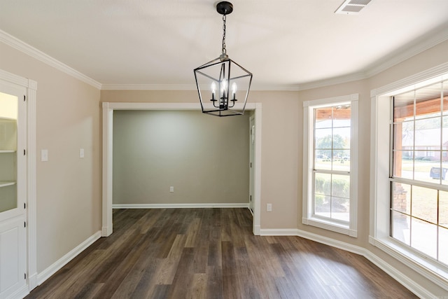 unfurnished dining area with crown molding, dark hardwood / wood-style floors, an inviting chandelier, and plenty of natural light