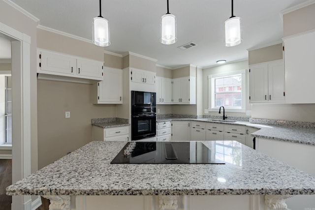 kitchen with ornamental molding, sink, black appliances, pendant lighting, and white cabinets