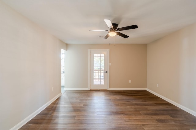 spare room with ceiling fan and dark hardwood / wood-style flooring