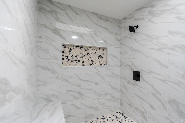 interior details featuring tiled shower