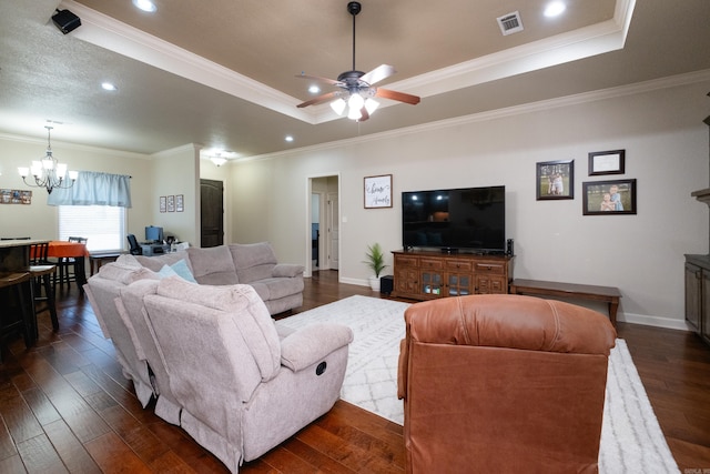 living room with ornamental molding, dark hardwood / wood-style floors, ceiling fan with notable chandelier, and a raised ceiling