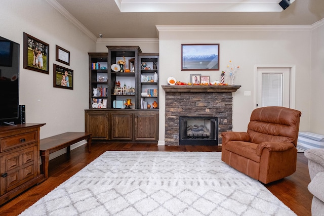 living room featuring dark wood-type flooring, ornamental molding, and a fireplace