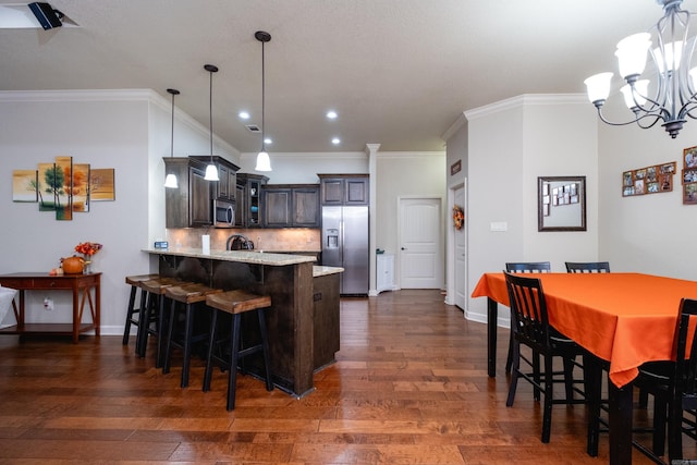 kitchen featuring dark brown cabinetry, appliances with stainless steel finishes, dark hardwood / wood-style flooring, and kitchen peninsula