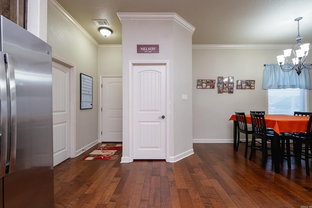 dining room featuring crown molding, an inviting chandelier, and dark hardwood / wood-style flooring