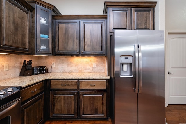 kitchen featuring backsplash, appliances with stainless steel finishes, dark brown cabinetry, and dark hardwood / wood-style floors