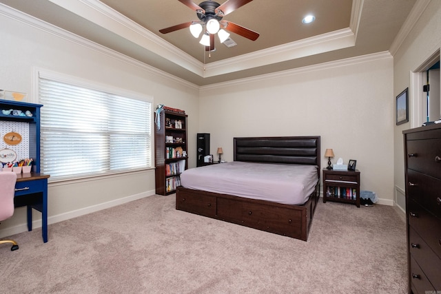 bedroom featuring crown molding, light colored carpet, a tray ceiling, and ceiling fan