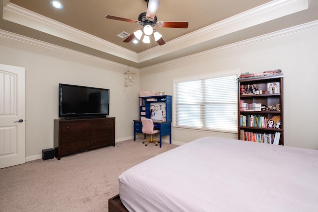 carpeted bedroom with ornamental molding, a tray ceiling, and ceiling fan