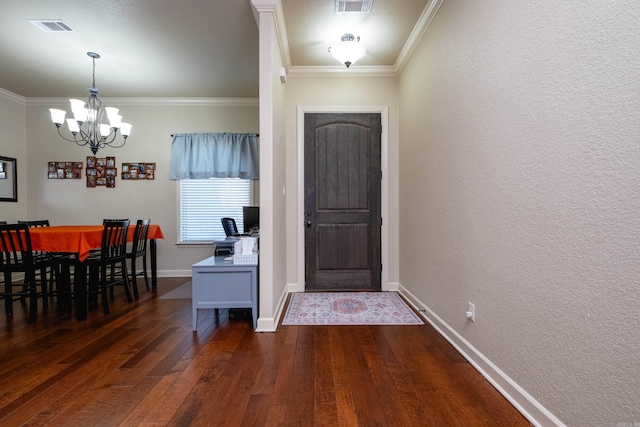 foyer entrance with ornamental molding, a chandelier, and dark hardwood / wood-style flooring