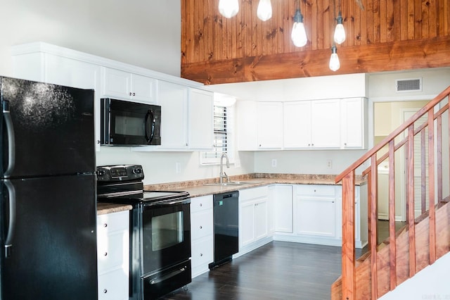 kitchen featuring black appliances, sink, dark hardwood / wood-style flooring, hanging light fixtures, and white cabinetry