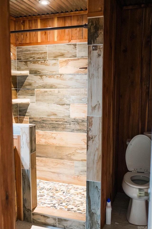 bathroom featuring toilet, wood walls, and wooden ceiling