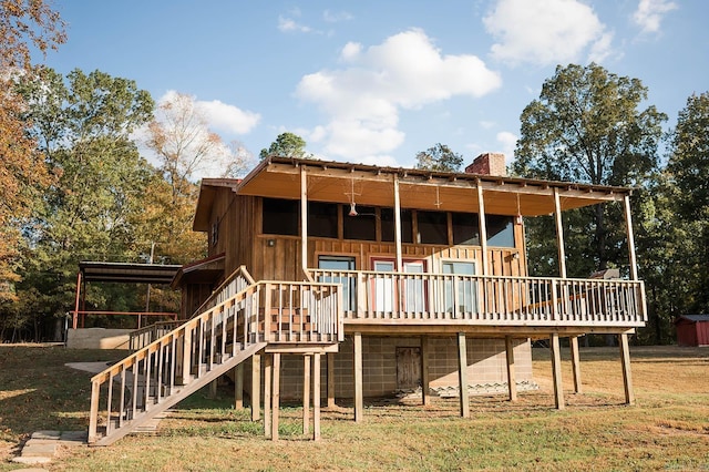 rear view of house featuring a wooden deck and a yard