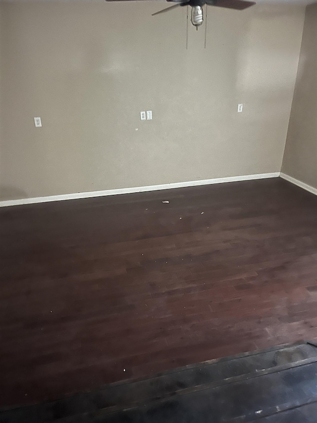 empty room featuring dark hardwood / wood-style flooring and ceiling fan