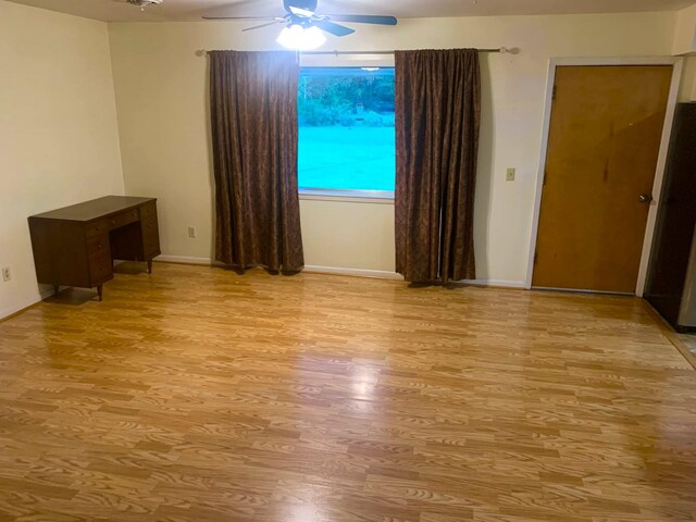 empty room with ceiling fan and light wood-type flooring