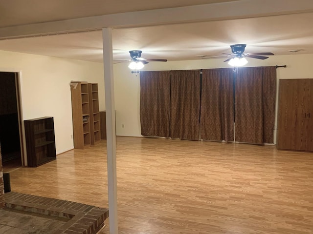 basement featuring ceiling fan and light wood-type flooring