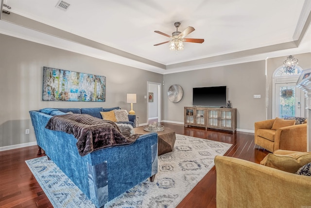 living room featuring ornamental molding, ceiling fan, a raised ceiling, and dark hardwood / wood-style flooring