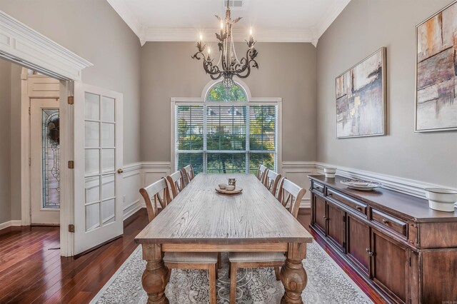 dining space featuring an inviting chandelier, crown molding, and dark hardwood / wood-style flooring