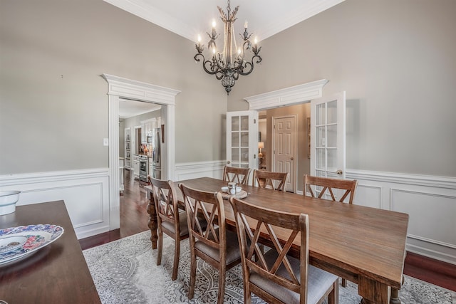 dining space with crown molding, dark hardwood / wood-style floors, a notable chandelier, and french doors