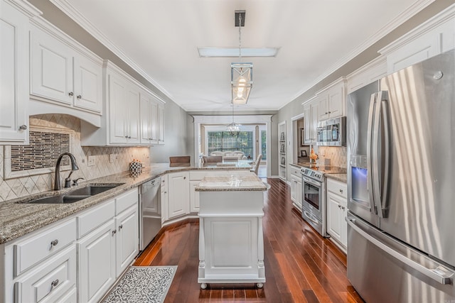 kitchen with dark wood-type flooring, appliances with stainless steel finishes, pendant lighting, and a kitchen island