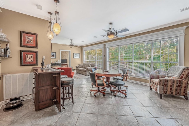 dining room with crown molding, radiator heating unit, and ceiling fan