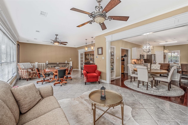 living room featuring ornamental molding, light hardwood / wood-style flooring, and ceiling fan with notable chandelier