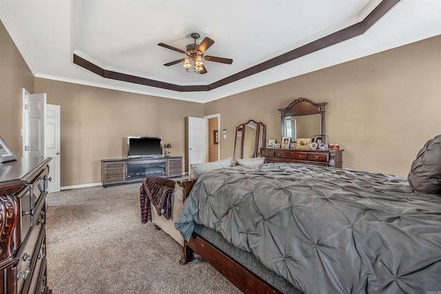 carpeted bedroom featuring ceiling fan, crown molding, and a tray ceiling