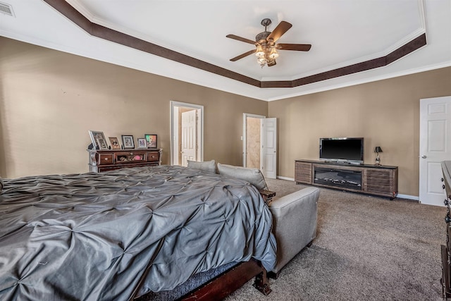 carpeted bedroom with ceiling fan, crown molding, and a tray ceiling