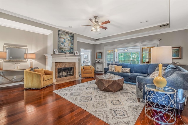 living room featuring ornamental molding, wood-type flooring, a fireplace, and ceiling fan