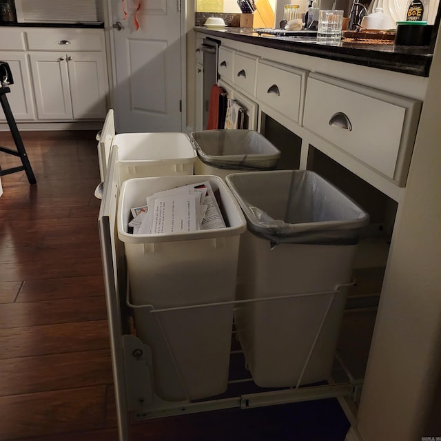 laundry area featuring dark wood-type flooring, washer and dryer, and cabinets