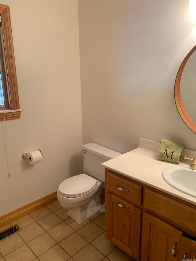 bathroom with toilet, vanity, and tile patterned flooring