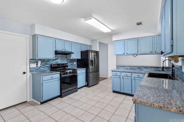 kitchen featuring sink, a textured ceiling, stainless steel appliances, blue cabinetry, and light tile patterned floors