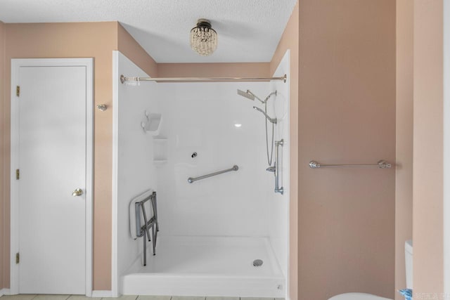 bathroom with a shower, a textured ceiling, and toilet