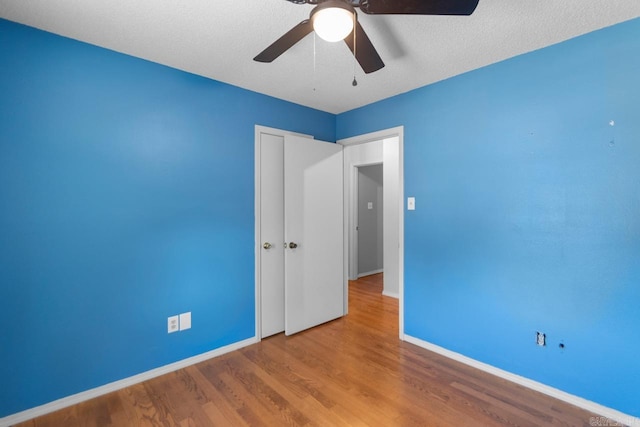 empty room with a textured ceiling, light hardwood / wood-style floors, and ceiling fan