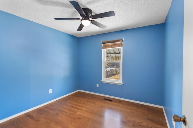 spare room with a textured ceiling, wood-type flooring, and ceiling fan