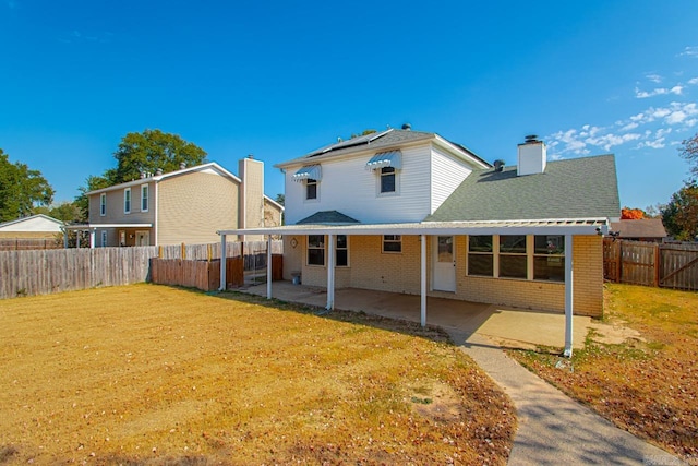 back of house featuring a patio and a lawn