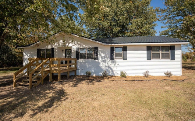 ranch-style house with a front yard and a wooden deck