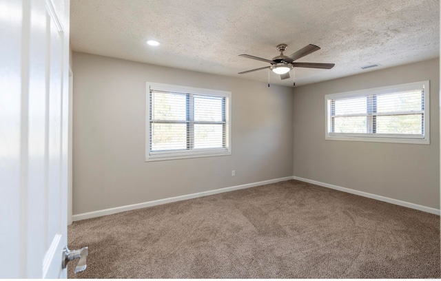 unfurnished room featuring ceiling fan, carpet, a textured ceiling, and a healthy amount of sunlight