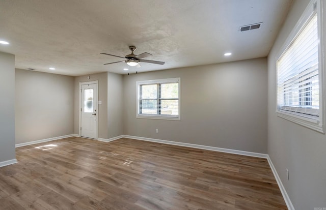 unfurnished room featuring a textured ceiling, hardwood / wood-style flooring, and ceiling fan