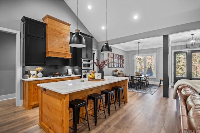 kitchen featuring light stone countertops, a center island, pendant lighting, and an inviting chandelier