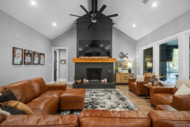 living room with ceiling fan, high vaulted ceiling, light hardwood / wood-style flooring, and a fireplace