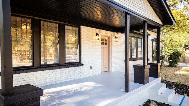 view of exterior entry featuring covered porch