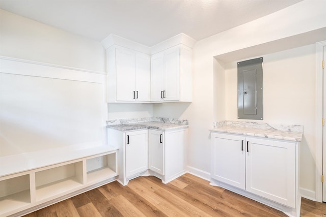 laundry area featuring electric panel and light hardwood / wood-style floors