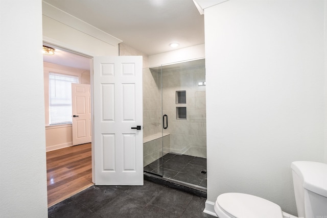 bathroom with toilet, hardwood / wood-style flooring, and a shower with shower door