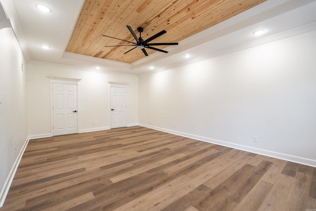 unfurnished room with ceiling fan, a raised ceiling, wood-type flooring, and wood ceiling