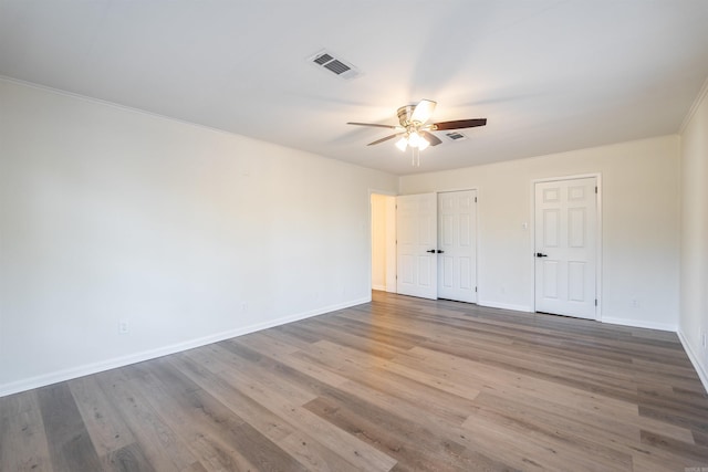 unfurnished bedroom featuring crown molding, wood-type flooring, and ceiling fan