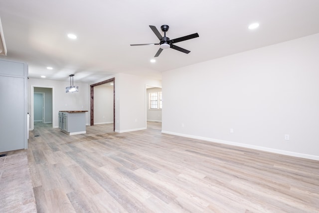 unfurnished living room with light wood-type flooring and ceiling fan