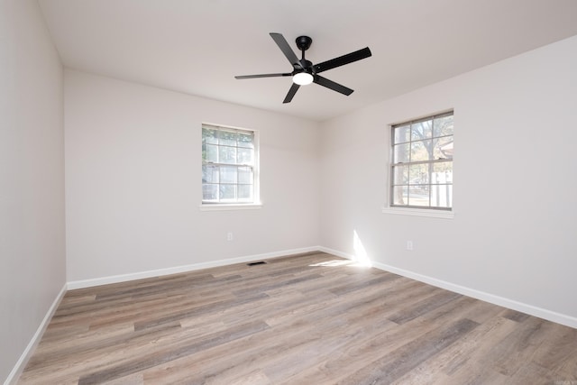 spare room with light wood-type flooring, plenty of natural light, and ceiling fan