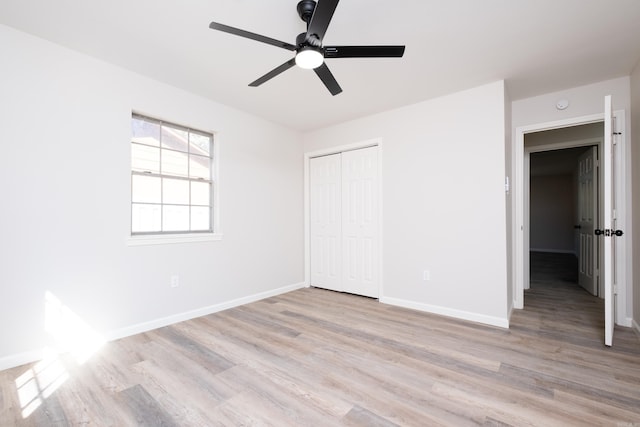 unfurnished bedroom with light hardwood / wood-style flooring, a closet, and ceiling fan