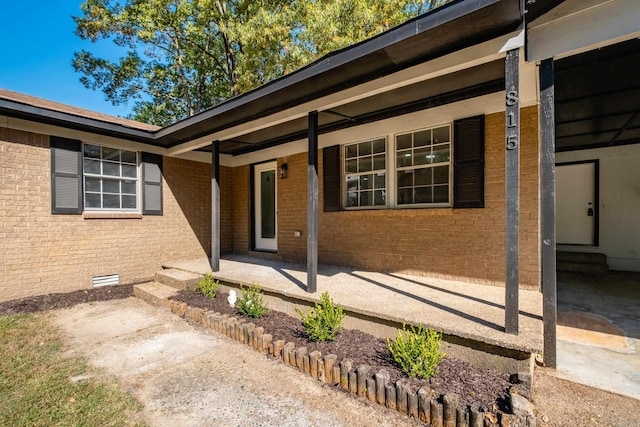 view of exterior entry with a patio