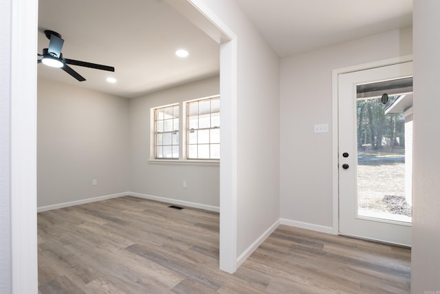 foyer entrance featuring ceiling fan, a wealth of natural light, and light wood-type flooring